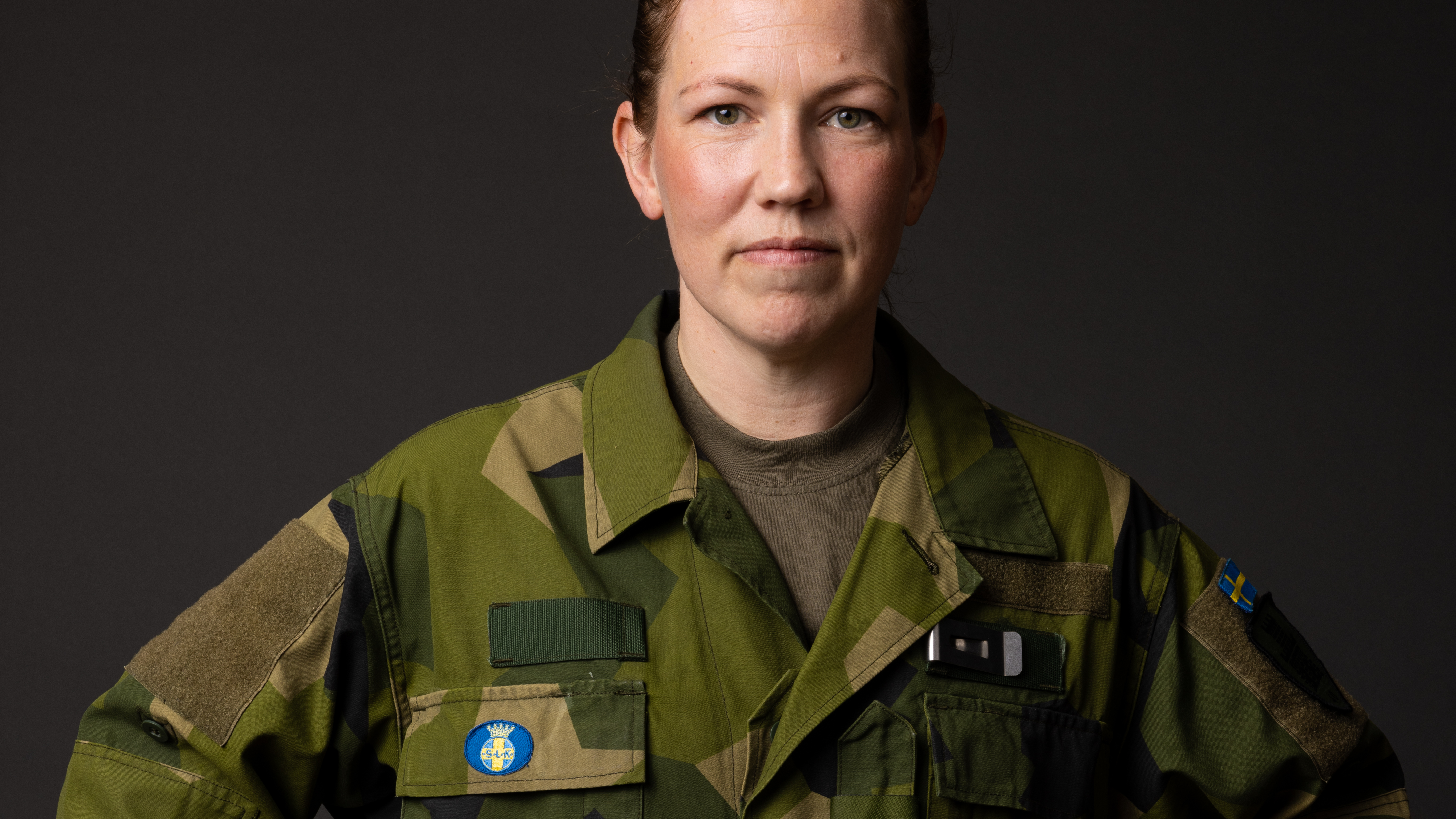 Kvinna i försvarsmaktens uniform med Svenska Lottakåren märke