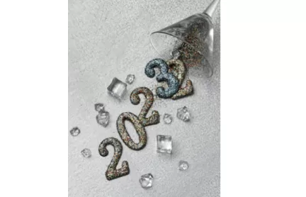 En bild där årtalen 2022 och 2023 runnit ur ett tippat glas, tvåan och trean på slutet ligger över varandra för att symbolisera övergången till ett nytt år.