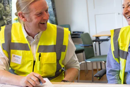 en man och en kvinna i varselvästar skrattar