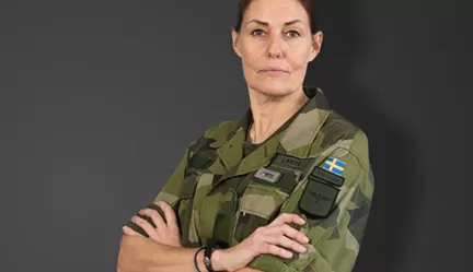 Kvinna i militär uniform med korsade armar