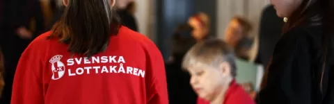 Kvinna med röd tröja märkt Svenska Lottakåren