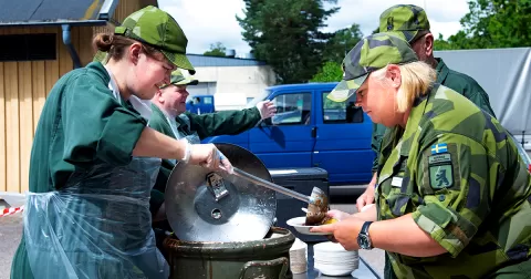 Fältkockar serverar mat till gäster