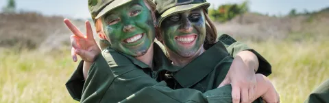 två unga tjejer som håller om varandra och har grön färg i ansiktet